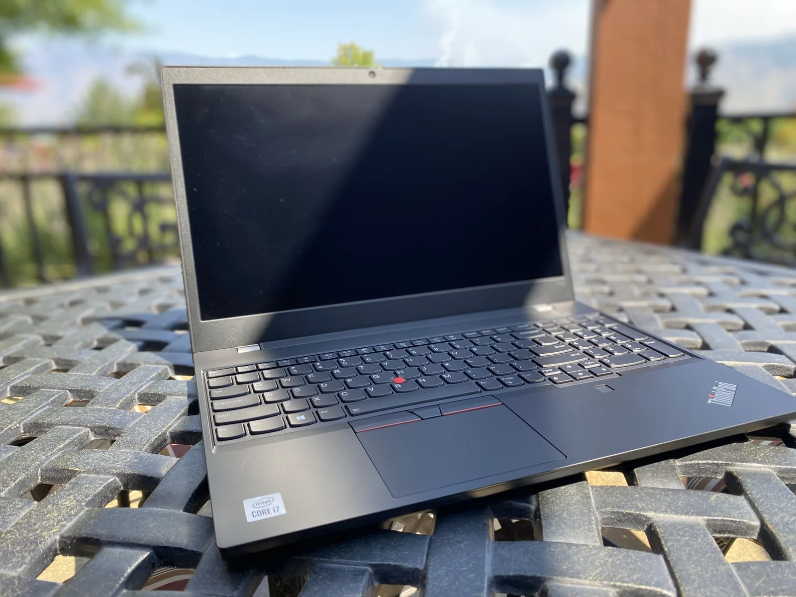 Laptop on an outdoor table with a vineyard landscape beyond